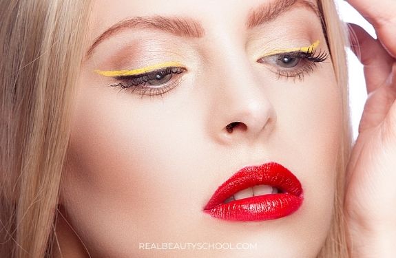 woman wearing yellow eyeliner with red lips