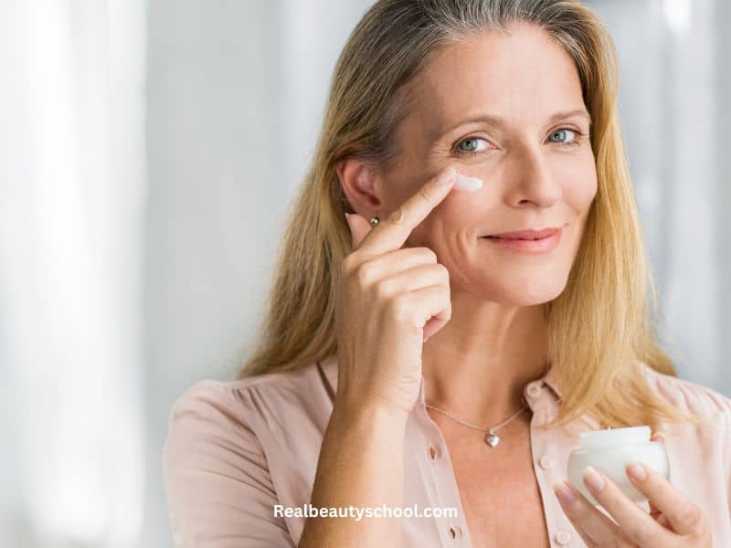 mature woman applying moisturizer to her face