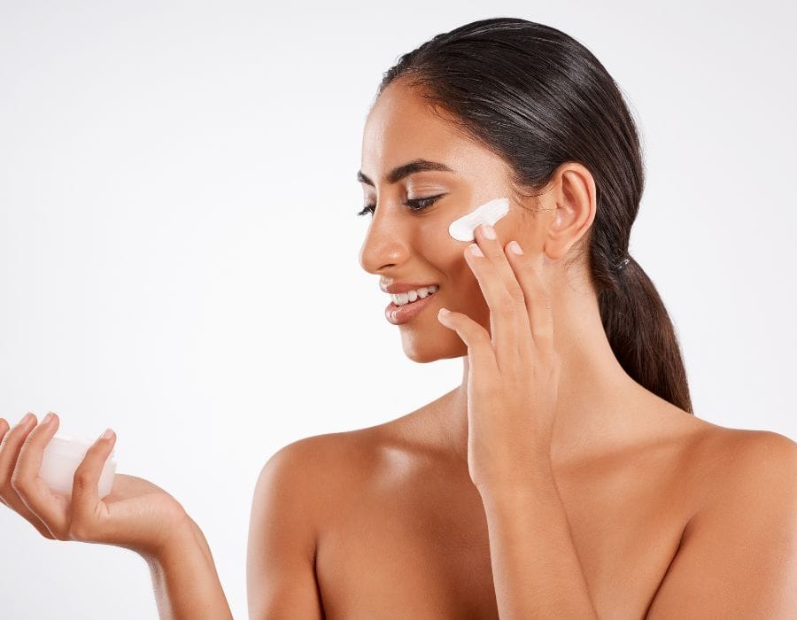 woman applying moisturizer